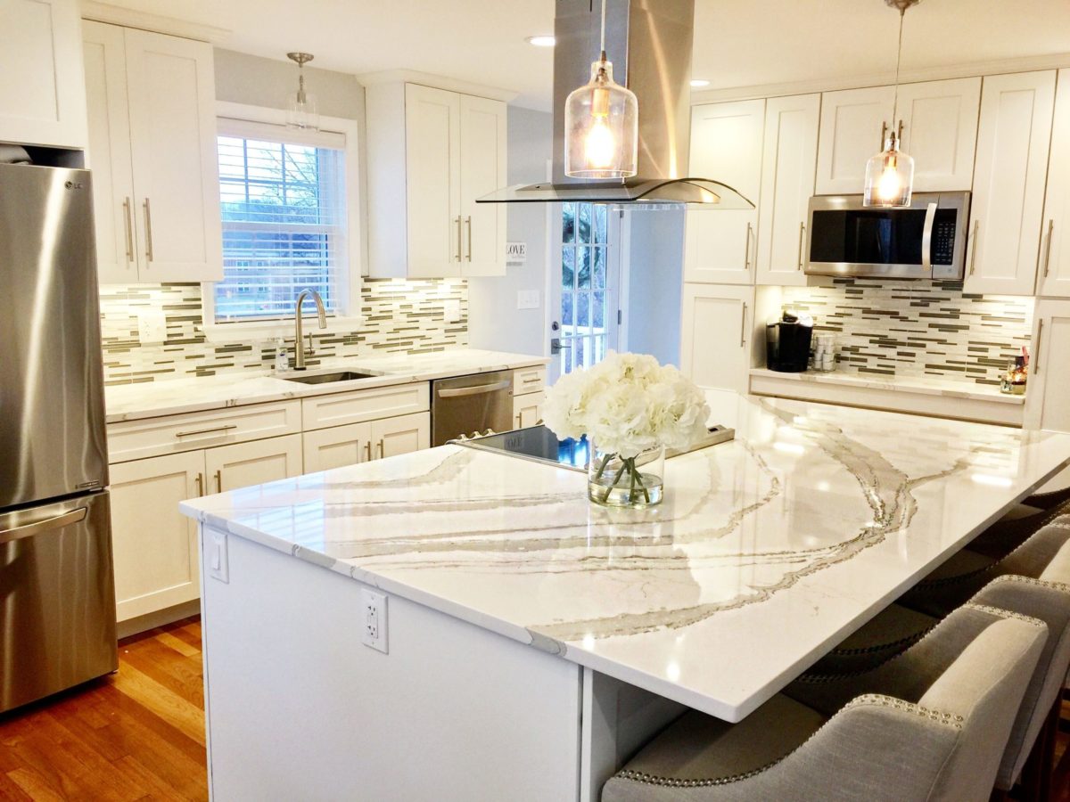 Brittanicca Warm Cambria Quartz Kitchen Countertops with White Cabinets, Stainless Steel, and Bar Stools