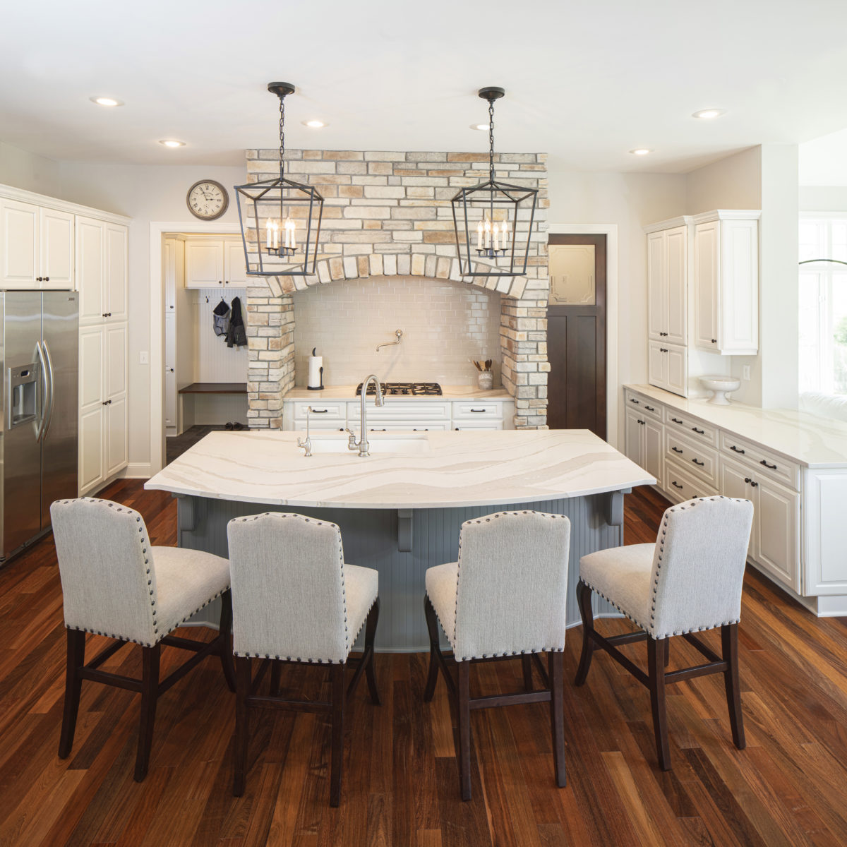 Brittanicca Warm Cambria Quartz Kitchen Countertops and Island with Cream Cabinets White Cabinets Pendant Lighting