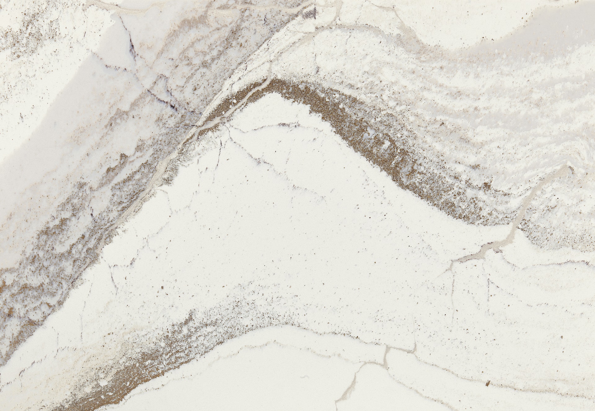 Windsor Brass Satin Ridge by Cambria Quartz: Experience the pinnacle of luxury and timeless elegance with this exquisite quartz surface. The design intricately blends rich chocolate brown tones with warm honey hues, all set against a textured canvas of debossed Inverness veins. Glistening brass elements meander across the surface, adding nuanced warmth, fluidity, and an unparalleled sheen. Offered in expansive jumbo slab sizes, this design is the ideal choice for creating lavish countertops, striking feature walls, and standout islands.